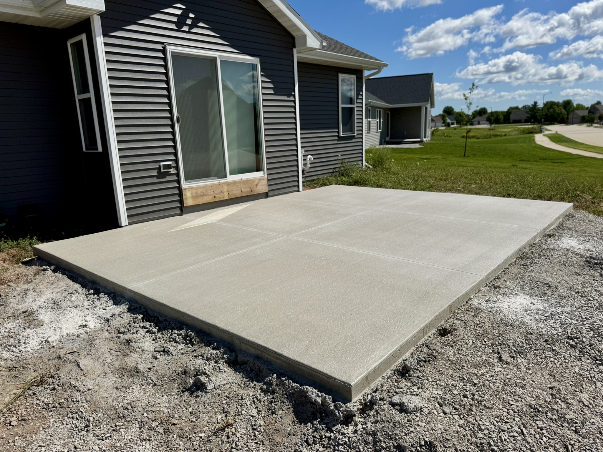 New concrete patio beside a residential home