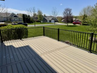 Composite deck with black metal railing overlooking a residential yard